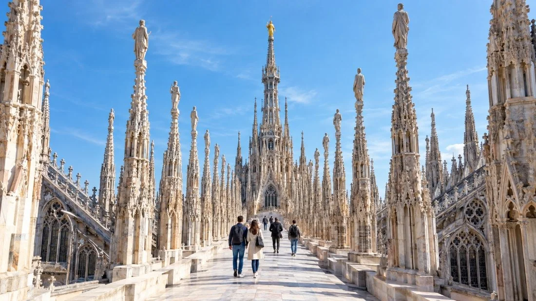 Des visiteurs marchant le long des terrasses du Duomo di Milano entre des rangées de flèches et de statues en marbre sculpté
